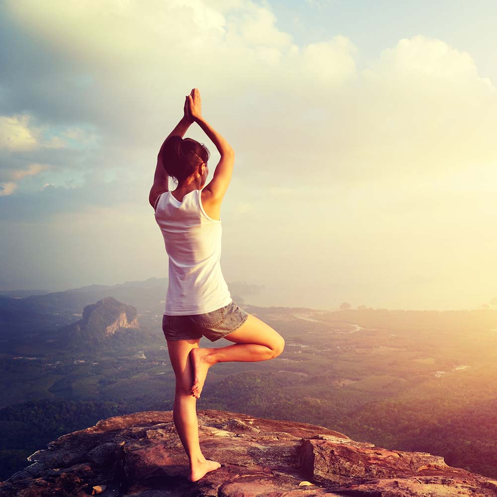 frau steht auf berg yoga