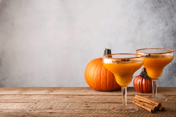 Pumpkin cocktail with cinnamon, orange juice and cocoa in glass mugs. Festive cocktail Halloween mar
